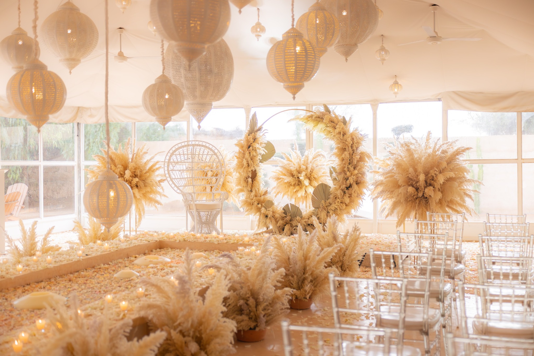 Ceremony in a permanent Moroccan tent with lanterns, floral arch and guest seating