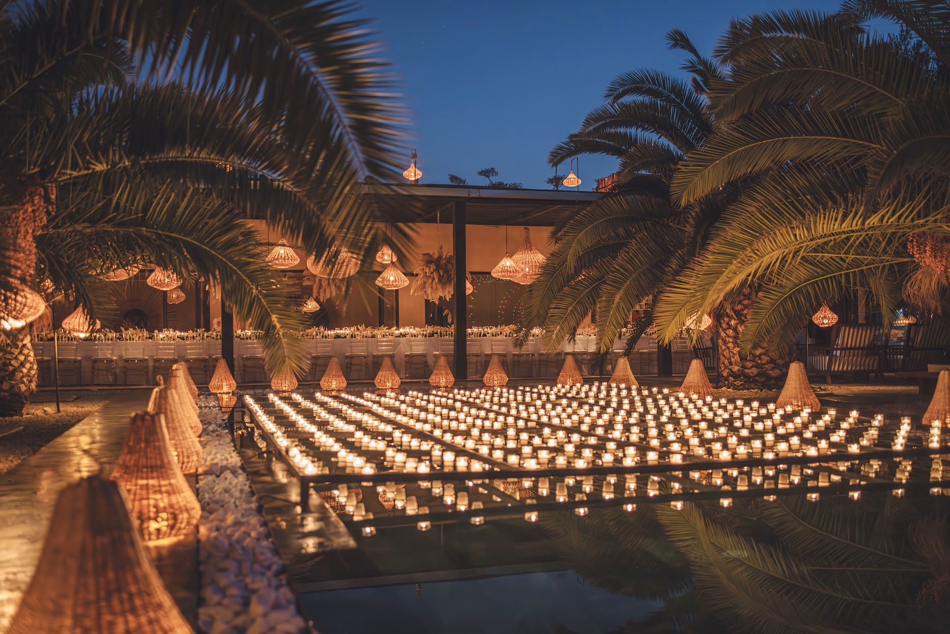 Réception de mariage à Villa Taj Marrakech, bassin éclairé à la bougie et palmiers