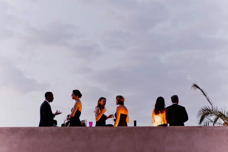 Guests chatting at a rooftop wedding reception in Marrakech